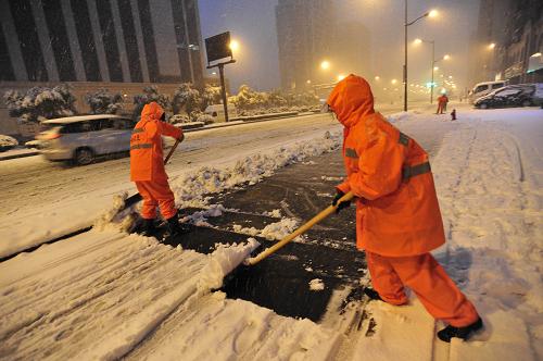 1月20日清晨,环卫工人在杭州市江干区凤起东路清除路面积雪。当日清晨,浙江省及杭州市气象台先后发布大雪和道路结冰黄色预警、暴雪橙色预警,连续的降雪导致浙江大面积积雪。清晨4时起,杭州市的环卫工人们就冒着风雪,在路灯下清除路面积雪,以方便市民出行。新华社发(来顺兴 摄)
