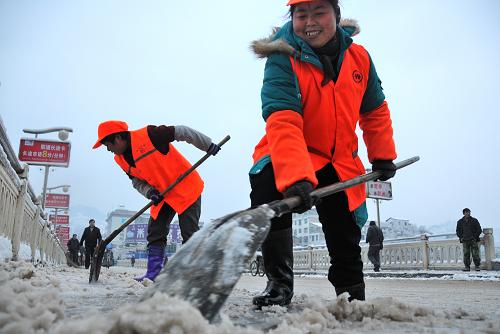 1月20日,湖北恩施宣恩县的环卫工人在街道上铲冰除雪。1月19日晚起,湖北恩施土家族苗族自治州宣恩县迎来降雪,城区部分地段积雪近10厘米。20日,该县城管执法、环卫工人、武警官兵及群众近千人走上街头,集中力量开展铲冰除雪,确保市民出行安全。新华社发(田丹 摄)