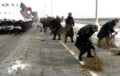 1月20日,武警九江支队官兵在九江长江大桥上除冰扫雪。应对持续降雪,九江长江大桥桥面出现结冰状况,武警九江支队官兵迅速集结来到大桥上除冰铲雪,确保交通畅通。新华社发(蔡杰 摄)