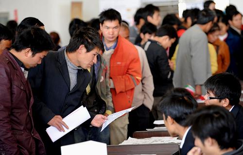 2月18日,一些求职者在昆明市南坝人力资源市场内查看招聘信息。新华社记者 蔺以光 摄