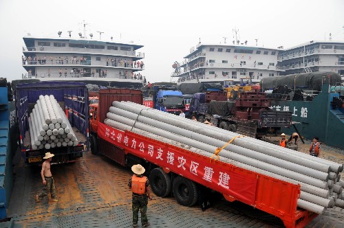 5月17日,运送电线杆的车队经三峡专用公路顺利抵达秭归银杏沱码头。运送这批救灾物资的车队将乘滚装船前往重庆万州,再经陆路抵达四川灾区。 湖北省电力公司根据国家电网公司要求,急调5500根水泥电线杆经水路运往四川灾区,维修受损电网。为了让这批救灾物资顺利进川,三峡有关部门开通了三峡专用公路放行。 新华社发(刘保平 摄)