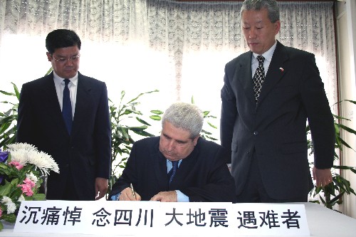 5月20日,在塞浦路斯首都尼科西亚的中国驻塞浦路斯大使馆,塞浦路斯总统赫里斯托菲亚斯(中)在吊唁簿上留言,悼念中国四川汶川大地震遇难者。 新华社记者王强摄