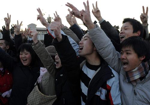 1月1日清晨,北京天安门广场举行隆重的升国旗仪式,来自全国各地的1.2万名群众冒着寒风观看升旗仪式,迎接2009年的到来。这是观看升国旗的群众共祝祖国新年好。新华社记者 唐召明 摄