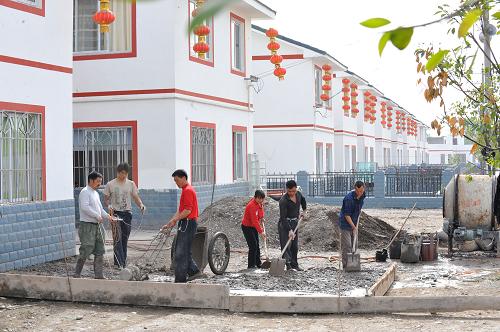 4月21日,方碑村村民为一户新房建屋前小院。汶川地震使四川省绵阳市安县方碑村的房屋垮塌95%以上,基础设施损毁严重。灾后方碑村在援建单位的帮助下,坚持以人为本、科学规划,一座座新房建起、一条条村路建成,目前已修建房屋390余户,修建进度完成95%。新华社记者 何俊昌 摄