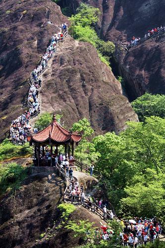 5月1日,游人在武夷山天游峰上排起长龙。当日是“五一” 小长假第一天, 武夷山天游峰上游人如织,但没有出现“井喷”现象,武夷山景区旅游秩序井然有序。新华社记者 张国俊 摄