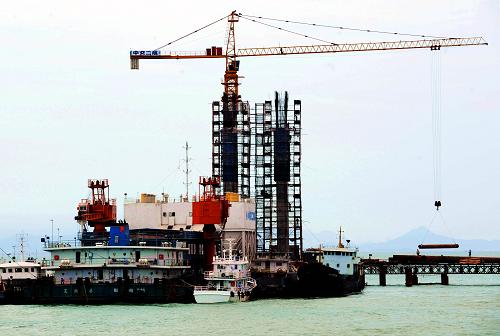 正在加紧建设中的福建平潭海峡大桥(7月26日摄)。 福建平潭海峡大桥自2008年2月正式动工以来施工进展顺利,即将进入主桥箱梁浇筑阶段,预计2009年底将完成所有桩基、承台施工,大桥力争在2011年元旦基本建成。 平潭海峡大桥起点位于福清市东瀚镇小山东,跨越海坛海峡,终点至平潭娘宫,路线全长4976米,其中桥梁总长3510米,双向4车道,设计行车速度80公里/小时,是平潭县未来进出岛的重要通道。 新华社记者 张国俊 摄