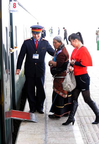 这是京藏车队第九包乘组列车员在那曲车站帮助旅客上车(3月28日摄)。北京客运段京藏车队值乘的T27/28次列车,从北京至拉萨全程4064公里, 单程运行约46小时30分。在青藏铁路线上,京藏车队470多名乘务人员克服高寒缺氧等困难,为广大旅客提供了热情周到的优质服务。他们注重提高服务细节,先后推出了汉、藏、英三种语言服务,以及10多种藏、回菜肴和介绍高原风光等13项服务内容,架起了民族团结的桥梁。新华社记者 唐召明 摄