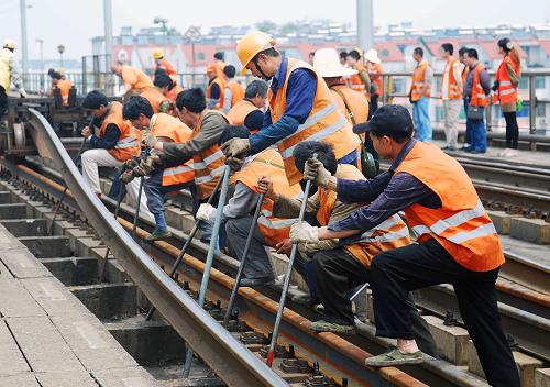5月10日,工人们为九江长江大桥铁路桥南引桥上行线更换钢轨。当日,南昌铁路局组织相关单位人员开始为九江长江大桥铁路桥更换钢轨。这是九江长江大桥铁路桥20世纪90年代建成通车后首次全面更换钢轨,大桥上、下行线路共计16公里的钢轨计划6月底全部更换完毕。新华社发(胡国林 摄)