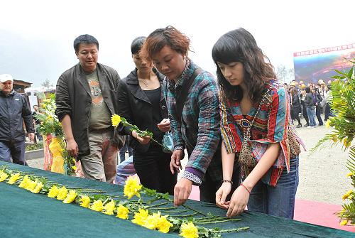 5月12日,活动参与者在大爱磐石前献花,寄托哀思。当日是汶川地震两周年纪念日。地震震中所在地汶川映秀镇组织乡镇机关、东莞援建工作组、施工队伍以及来自全国各地来此祭奠的人士,在映秀震中遗址的大爱磐石前开展“缅怀过去、展望未来”献花活动,寄托哀思。新华社记者 何俊昌 摄
