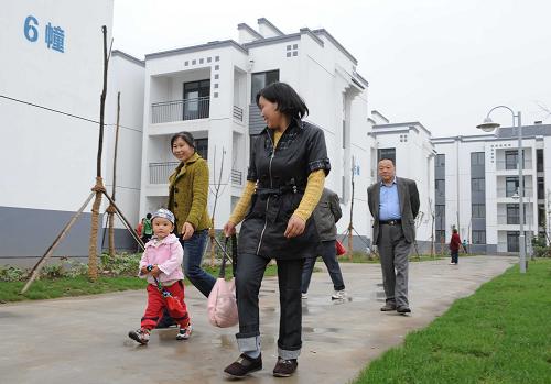 5月12日,汉旺镇居民在刚刚竣工的汉锡花苑参观。当日是汶川地震两周年纪念日,许多绵竹市民前往汉旺,吊唁地震中失去的亲人和朋友。与此同时,江苏省无锡市对口援建汉旺镇的22个项目,也竣工交付使用,一个美丽的新汉旺,已经在地震遗址旁崛起。新华社记者 陈燮 摄