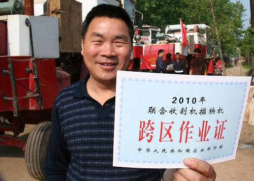 5月12日,山东省郯城县郯城镇红青农机服务合作社农机手赵振启展示领到的跨区作业证。当日起,山东省郯城县1000余台安装有秸秆切碎装置的收割机将陆续前往河南、安徽、湖北等地进行跨区麦收作业。山东省郯城县农机部门组织技术人员深入到村,举办培训班,送发跨区作业证,为机手备战跨区作业提供服务。新华社发(张春雷 摄)