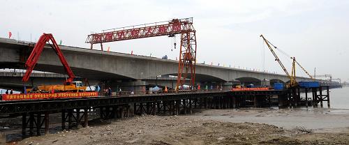 这是建设中的钱江铁路新桥(5月26日摄)。5月26日,我国首座四线高速铁路连续桥梁——浙江杭州钱江铁路新桥顺利实现主桥精确合龙。2008年4月开工的钱江铁路新桥是杭甬客运专线、沪昆客运专线关键控制性工程,全长2222米,其中主桥长1340米,由铁道部、浙江省和杭州市共同出资组织建设。钱江铁路新桥桥面设计为四线铁路客运专线,并采取18跨整体连续梁桥结构,在我国高速铁路桥梁中首次采用,设计时速为250公里。该桥是继钱江一桥、钱江二桥之后钱塘江上建设的第三座铁路桥梁。新华社记者 韩传号 摄