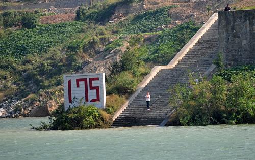 一位村民站在三峡库区内的秭归县郭家坝镇175米蓄水牌旁(10月22日摄)。新华社记者 郝同前摄