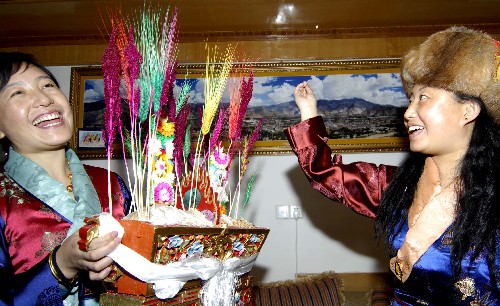     拉萨市的藏族妇女手捧寓意五谷丰登的"切玛",互相