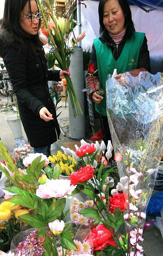 1月25日,市民在上海街头选购鲜花。春节前夕,上海消费品市场购销两旺。一月份前三周上海大型综合超市销售同比增长25.5%,标准超市和市内菜市场销售同比分别增长24.2%、19.1%,上海市商委商业经济运行部门预计一月份上海消费品市场零售额有望同比增长20%以上。新华社记者 陈飞 摄