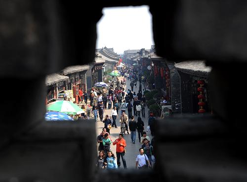 10月2日,游客在平遥古城景区游览。国庆长假期间,山西省平遥古城景区内游人如织,古色古香的明清建筑让游人们流连忘返。 新华社记者 燕雁 摄