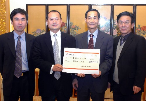 2月5日,香港新华集团蔡冠深先生(左二)将支票交给中央人民政府驻香港特别行政区联络办公室副主任黎桂康(右二)。 新华社记者 黄本强 摄