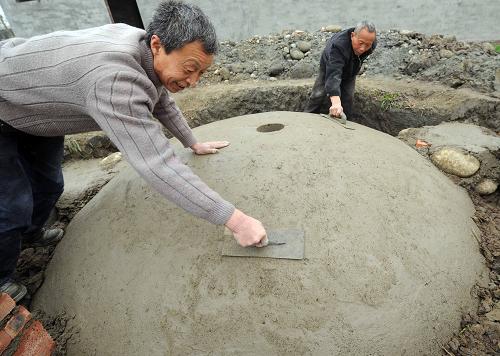 2月7日,沼气技术人员在绵竹市新市镇花园村7组农户江昌全家修建沼气池。新华社记者 李晓果 摄