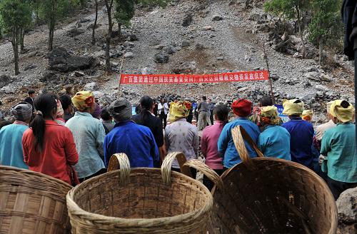 3月27日,在广西百色市凌云县泗城镇后龙村,瑶族同胞在等待领取救灾物资。当日,广州百货企业集团通过中国扶贫基金会向广西百色市凌云县赠送的纯净水与大米被及时送到旱区群众手中。目前,广西百色市旱情依然严峻。为帮助灾区群众渡过难关,社会各界纷纷行动起来,捐款捐物,为灾区群众献爱心。新华社记者 周华 摄