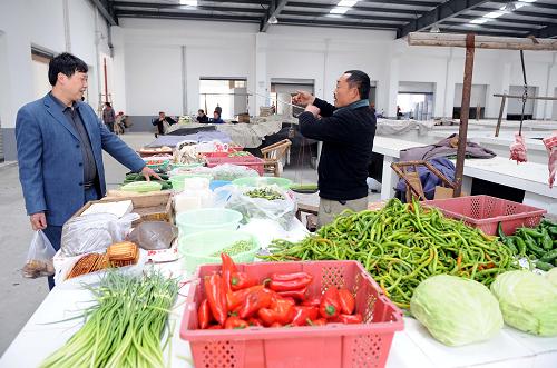 一位顾客在江苏省太仓市援建的绵竹市齐天镇农贸市场买菜(摄于3月24日)。新华社记者陈燮摄