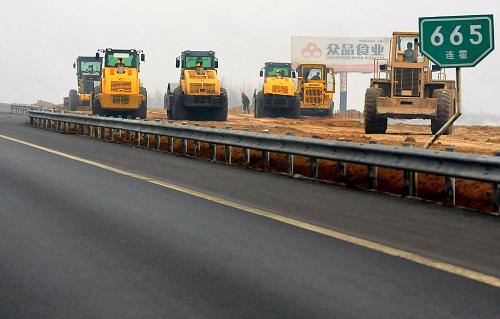 3月30日,在连霍高速公路改扩建工程郑州境内的一个工地上,几台压路机在碾压新铺设的路基。新华社记者王颂摄