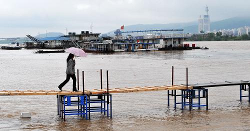 不断上涨的水位使得长沙市湘江边停泊的船只纷纷临时搭建跳板以供人员出入(4月21日摄)。受持续连日高强度降雨的影响,湘江中下游水位以每小时约5厘米的速度猛涨。截至4月21日上午8时,湘江长沙段水位已涨至34.6米,直逼36米的警戒水位。当地水文部门预计,长沙未来两天还有强降雨,湘江长沙段可能突破警戒水位。目前,长沙防汛部门已进入临战状态,严密监控湘江水情变化,确保防洪安全。新华社记者 龙弘涛 摄