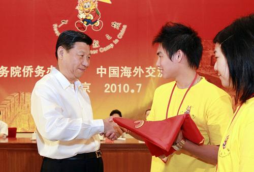 7月25日,中共中央政治局常委、国家副主席习近平在北京人民大会堂出席2010年海外华裔及港澳台地区青少年“中国寻根之旅”夏令营开营式并讲话,向营员代表颁授营旗。这是习近平向营员代表颁授营旗。 新华社记者 谢环驰 摄