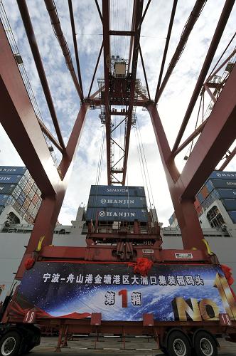 7月25日,宁波—舟山港金塘港区大浦口集装箱码头工作人员为停靠码头的首航船装货。新华社发