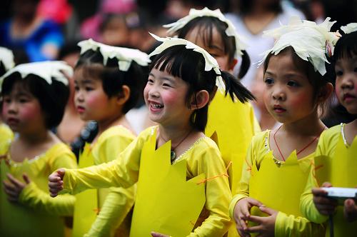 6月1日,广州市蓝精灵幼儿园的孩子们在观看同伴们的演出时露出灿烂的笑容。当日是“六一”国际儿童节,广州市蓝精灵幼儿园的小朋友们在幼儿园举行的文艺演出上展示自己的各种才艺,欢庆自己的节日。新华社记者 陈晔华 摄
