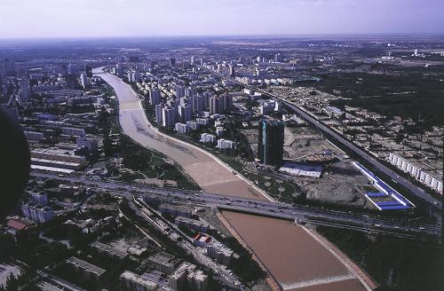起源于博斯腾湖的孔雀河从库尔勒市穿城而过,河边高楼林立,绿树成荫(资料照片)。新华社发(李翔 摄)