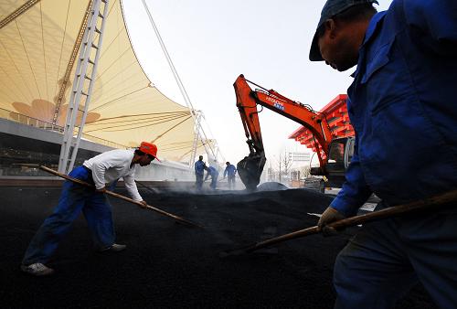 3月16日,工人在上海世博园区内铺设道路。新华社发