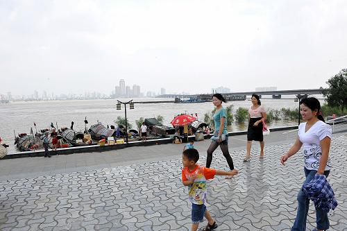 6月26日,市民从赣江南昌段走过。新华社记者 何俊昌 摄