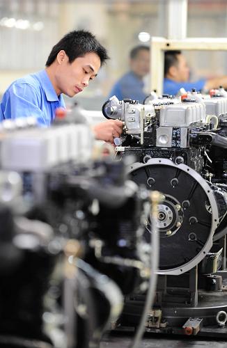 广西玉柴集团的技术工人在发动机生产流水线上操作(7月22日摄)。新华社发(刘钦明 摄)