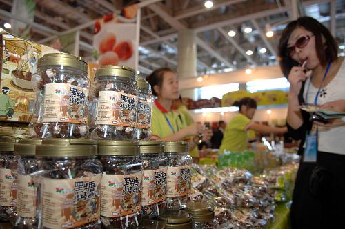 9月23日,在烟台国际博览中心,来自台湾的参展商向与会嘉宾推销产品。新华社记者 郭绪雷 摄