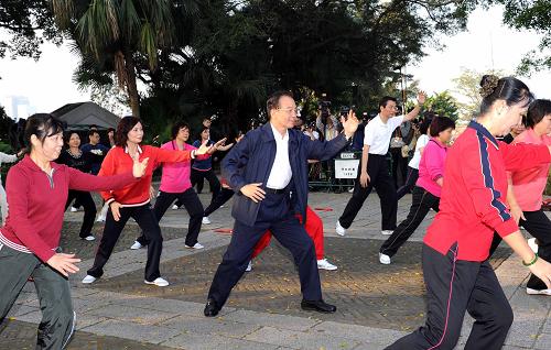 11月14日,国务院总理温家宝来到澳门大炮台花园,同在这里晨练的市民亲切交流,一起练习太极拳并学练太极扇。新华社记者 饶爱民 摄
