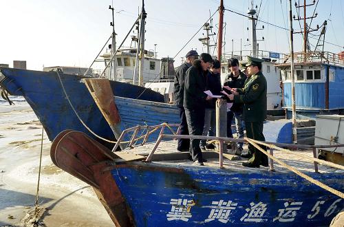 沧州市南排河边防派出所民警在向渔民发放有关防范海冰的宣传材料(1月8日摄)。新华社记者 杨世尧摄