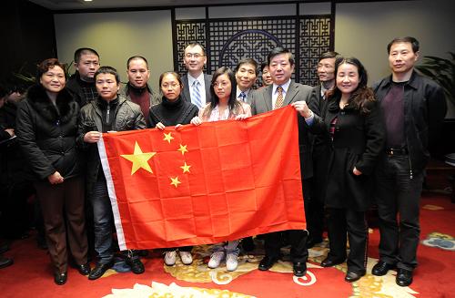 1月27日,中国公民在北京首都国际机场与外交部工作人员合影。当日,48名滞留海地的中国公民随结束海地救援任务的中国国际救援队乘包机安全抵达首都机场。 新华社记者 金良快 摄