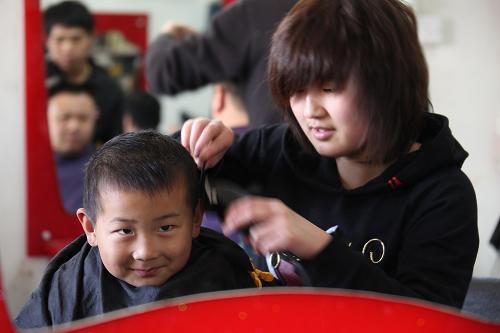 3月17日,顾客在北京市西城区一条胡同里的澜麒理发店理发。当日是农历二月初二,民间有“二月二,龙抬头”的说法,许多市民来到理发店修剪头发,大家认为在二月二这天剃头,会像龙一样从冬眠中醒来,开始活动,图个好兆头。新华社记者 邢广利 摄