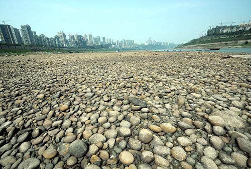 这是长江重庆段一处大面积裸露的河滩(3月26日摄)。记者从重庆市防汛抗旱指挥部了解到,近段时间以来重庆大部地区降下小到中雨,对缓解旱情起到了明显作用。但是由于降水未形成有效径流,目前流经重庆的长江等大江大河仍维持特枯水位,船舶航行仍存安全隐患。长江上游水文局监测数据显示,3月26日8时,重庆长江寸滩站水位为158.82米,流量为2970立方米/秒,与24日相比,水位下降了0.45米,每秒流量减少了420立方米。目前长江重庆水位较常年偏低1.5至2米,仍维持特枯水位。新华社记者 周衡义 摄