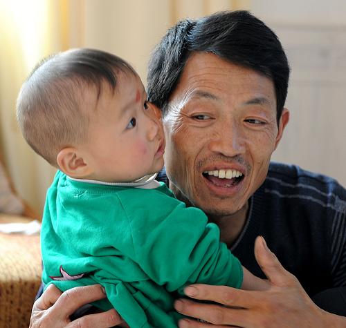 5月10日,王俊杰和父亲王兴林在一起。王兴林是个泥瓦匠,自从有了儿子,他干活更加卖力了。2008年,本来已经要当外婆的四川绵竹市九龙镇妇女黄长容,再次当妈妈了。黄长容的女儿王莉在“5·12”地震中不幸遇难,遇难时已有6个月身孕。在国家地震灾区“再生育全程服务行动”的关怀下,已经42岁的黄长容再次怀孕,并于2009年3月生下儿子王俊杰。儿子的降生,为这个一度充满悲伤的家庭,重新带来希望和活力。汶川地震后,国家拨出上亿元专项资金,启动了灾区“再生育全程服务行动”,对在地震中计划生育家庭有子女死亡或伤残并有再生育愿望的妇女,实行孕前、孕期、分娩及治病等全程免费服务。在这项行动的关怀下,四川迄今已诞生了2000多个宝宝。绵竹市是“再生育全程服务行动”最早启动的地方。2008年6月30日,该市人口计生局与沈阳军区抗震救灾野战医院一起,共同开启了再生育关怀活动。目前,绵竹市有再生育意愿的850多名妇女中,已经有528人当了妈妈,还有91人已是准妈妈。新华社记者 陈燮 摄