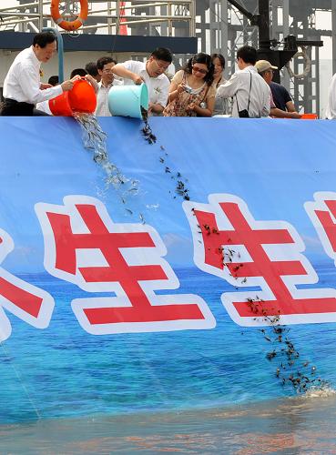 6月6日,活动参与者在向长江放流鱼蟹种苗。新华社记者 孙参 摄