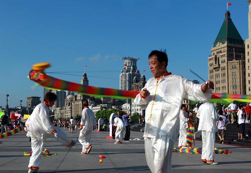 8月8日上午,来自上海市黄浦区的市民在外滩亲水平台上扯风铃。当日是全国“全民健身日”,上海市举行“全民健身与世博同行”主题活动启动仪式,数千名市民展示了木兰拳、扯铃、排舞、健身操、太极拳、跳绳等多项健身项目。新华社记者 任珑 摄