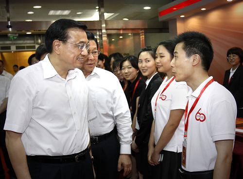 8月12日,中共中央政治局常委、国务院副总理李克强在北京参观中国对外援助60周年纪念展。这是李克强与我国参加对外援助的志愿者交谈。新华社记者 刘建生 摄