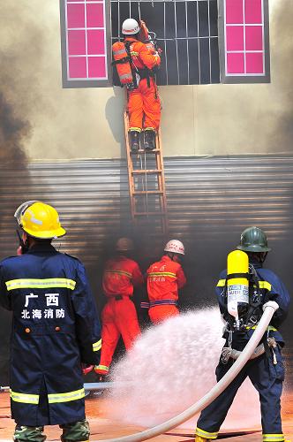 8月31日,在广西东兴市综合应急救援演练现场,消防人员强行破拆“发生爆炸”的宾馆窗户,救援被困人员。新华社发