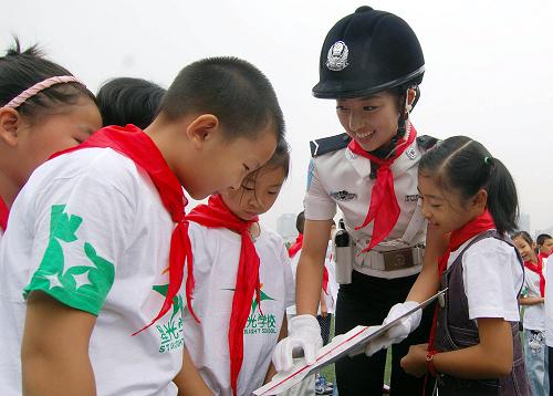 9月1日,重庆市女子交巡警总队队员向星光小学学生讲解交通安全宣传画册上的相关内容。新华社记者 陈诚 摄