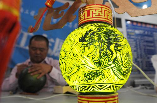 9月6日,浙江志愿者正在乌鲁木齐新疆维吾尔自治区图书馆展览现场制作西瓜灯。当日,浙江文化志愿者正式启动了在新疆的文化援疆活动。志愿者组织了文化志愿讲师团和展览作品,将分别在乌鲁木齐市、阿克苏地区及新疆生产建设兵团农一师开展为期15天的“大展台”“大讲堂”活动,其中包括具有浙江地域特色的摄影图片展、浙江非物质文化遗产手工技艺现场展示、有关音乐、舞蹈的专项讲座等。该活动是文化部“全国文化志愿者边疆行”的一项重要内容,旨在为内地和边疆民族地区搭建一个交流互动的平台,为新疆文化队伍建设的发展提供了精神动力和智力支持。新华社记者 王菲 摄