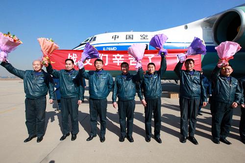 3月4日,圆满完成运输任务的空军运输机机组人员向欢迎人群致意。新华社记者 查春明 摄