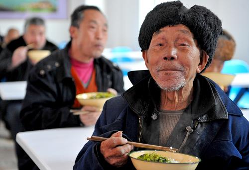 岚皋县溢河乡高桥村中心敬老院的五保老人在吃晚饭。该敬老院于2010年12月底投入使用,可供100名老人一起居住,目前有40位老人在该敬老院生活(3月23日摄)。陕西省岚皋县位于鄂、渝、陕三省交界处,属于国家级贫困县。近年来,岚皋县依托当地得天独厚的生态旅游资源大力发展生态旅游产业,实现以旅游业为龙头,各行各业联袂突破发展的局面,县域经济以年均13%以上的速度跃升。在经济发展的同时,民生工程也成为岚皋县发展的重点,全力保障困难群众的生活更是重中之重。2010年,岚皋县80%的财力倾斜向农村、基层和困难群众。全县17个乡镇,每个乡镇都建有敬老院和五保老人集中供养点。2010年全县1680户2205名农村五保老人得到集中供养,集中供养率达67%,对未集中供养的老人实行托养政策,政府出资进行生活补贴。对于城市低收入群体,岚皋县大力推行廉租房及经济适用房建设,1046户3138人纳入廉租房保障项目,1100户2970名困难干部职工成为经济适用房保障对象,首批140套廉租房,68套经济适用房已经入住。新华社记者 刘潇 摄