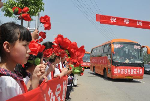 5月5日,河南省淅川县大石桥乡西岭村移民群众的搬迁车队途经淅川县城区,道路两旁10余万人送行移民亲人。当日,河南省淅川县大石桥乡西岭村的147户693名移民登上了开往邓州市腰店镇移民安置点的客车,这标志着南水北调丹江口库区第二批移民搬迁正式启动。据悉,此次移民搬迁将持续到8月底,共涉及河南省淅川县的10个乡(镇),约8.6万人,搬迁完成后,河南省丹江口库区的移民搬迁工作也将基本结束。新华社发(杨振辉 摄)