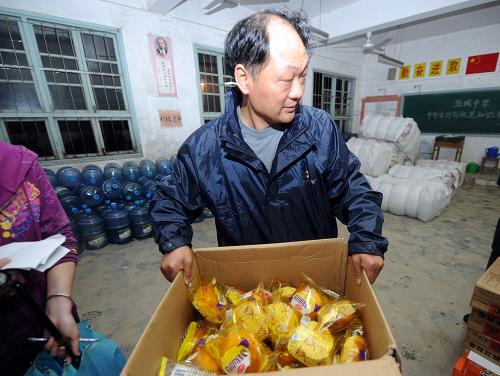 6月14日,安置点的工作人员准备给转移群众发放食品。连日来,安徽省黄山市休宁县连遭暴雨袭击,该县多处地质灾害点随时有遭遇险情的危险。从13日夜开始,当地政府根据险情陆续撤出各个地质灾害点的群众。6月15日凌晨1时40分,休宁县柳家坑村的最后一批37位村民,顺利转移至临近安置点。据介绍,从13日夜至15凌晨,当地政府共组织转移安置群众1100多人。新华社记者 郭晨 摄